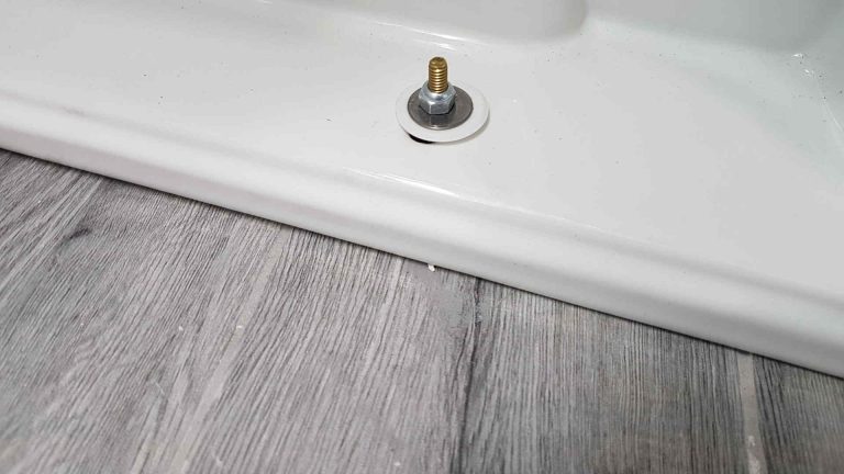 Should flooring go under or around toilet?